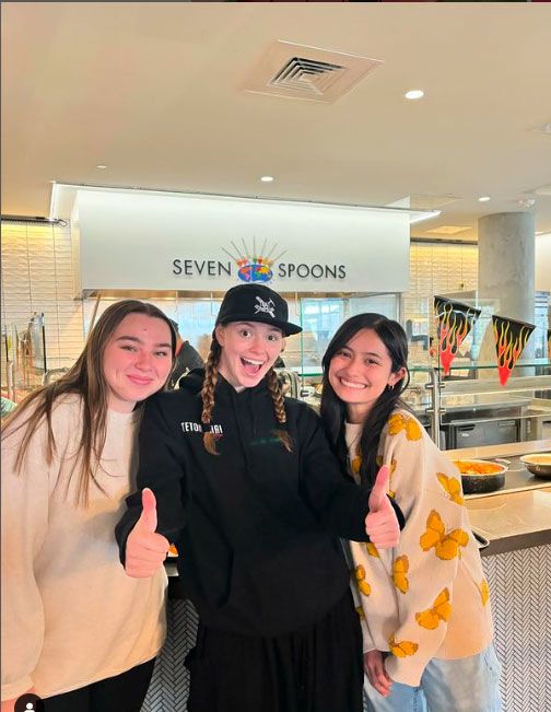 three DU students posing together at dining hall