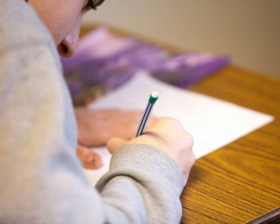DU student working with paper and pencil