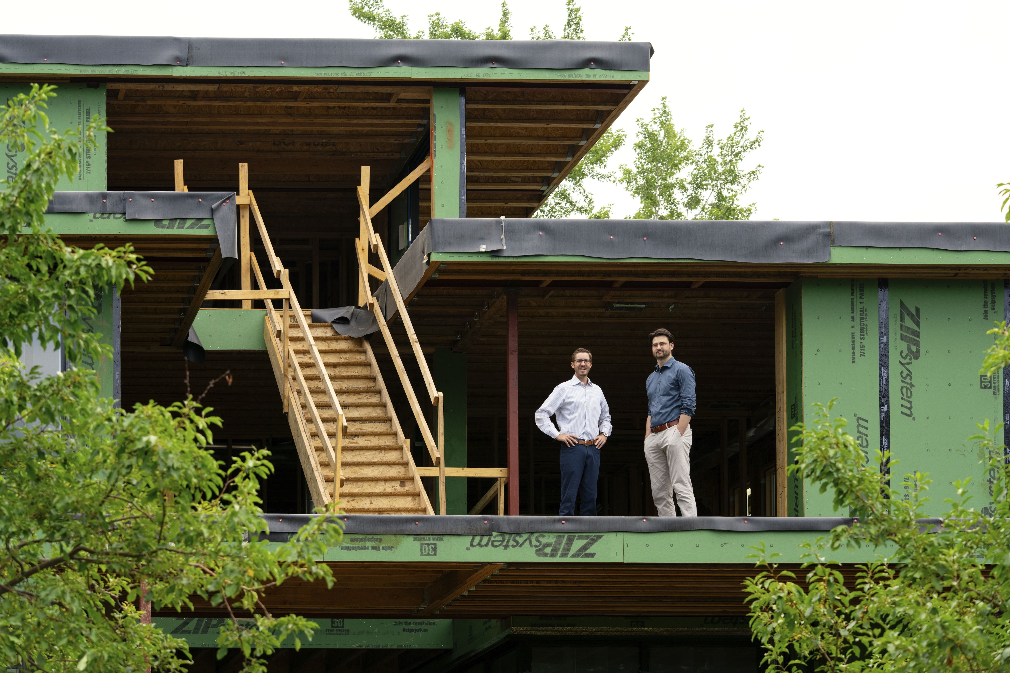 Two men standing in a house under construction