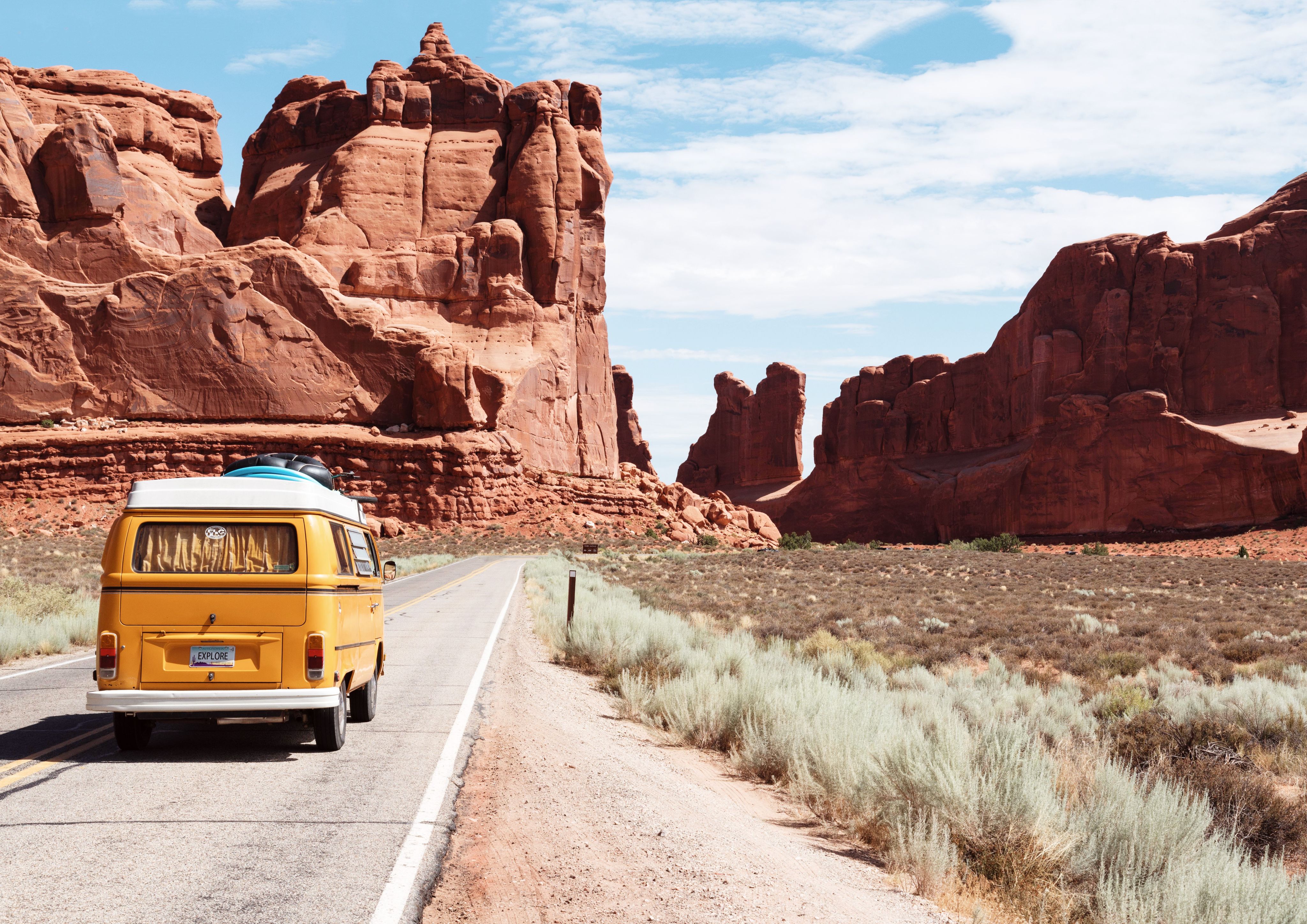 yellow Volkswagen van on two-lane road in a desert, southwestern scene