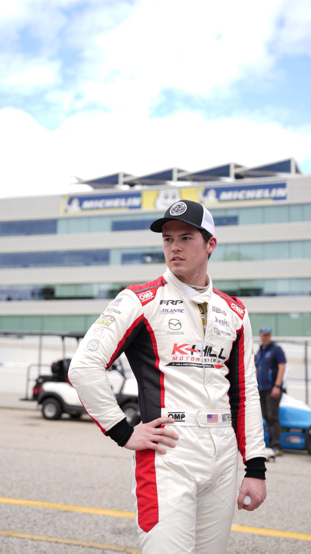 Matthew Butson in a white and red racing uniform and a black hat