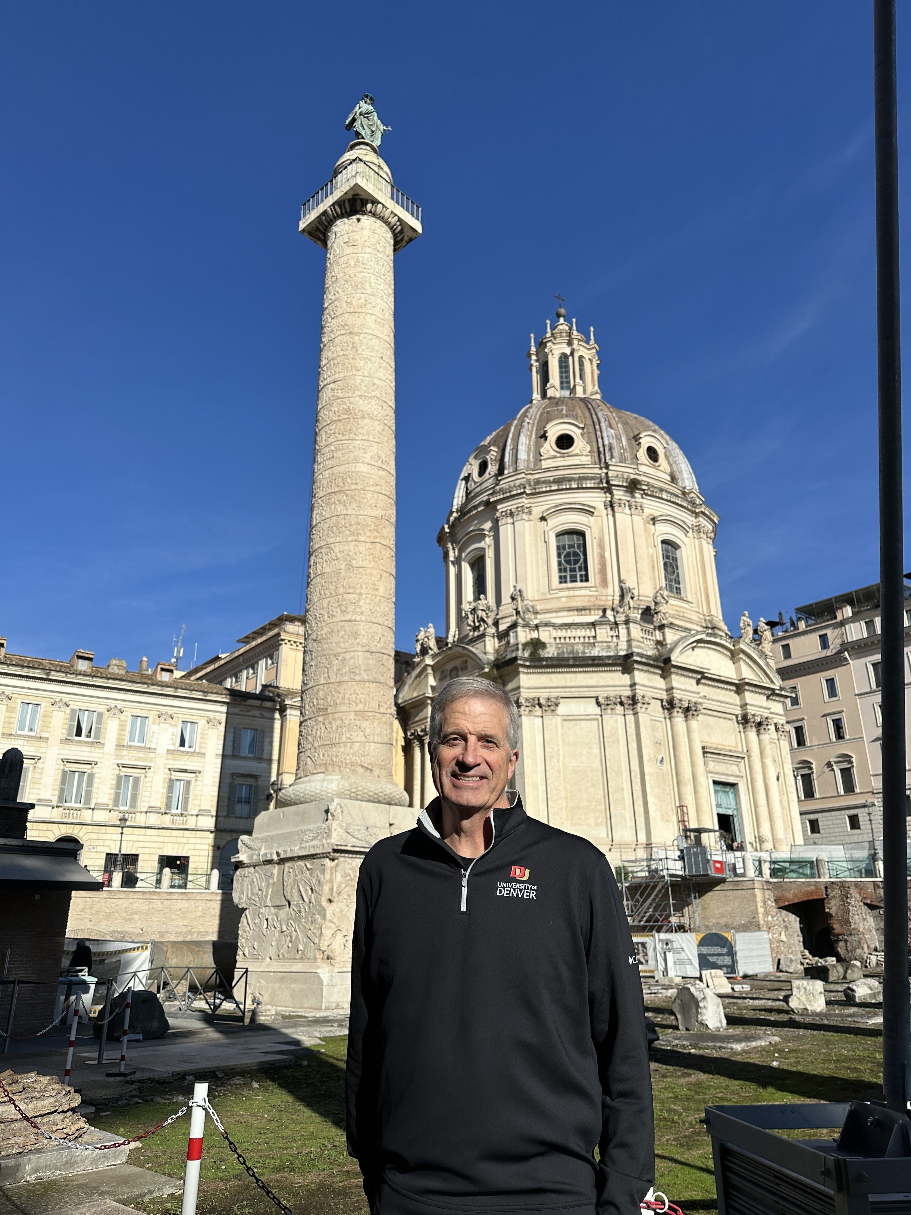 a man smiling in front of a building