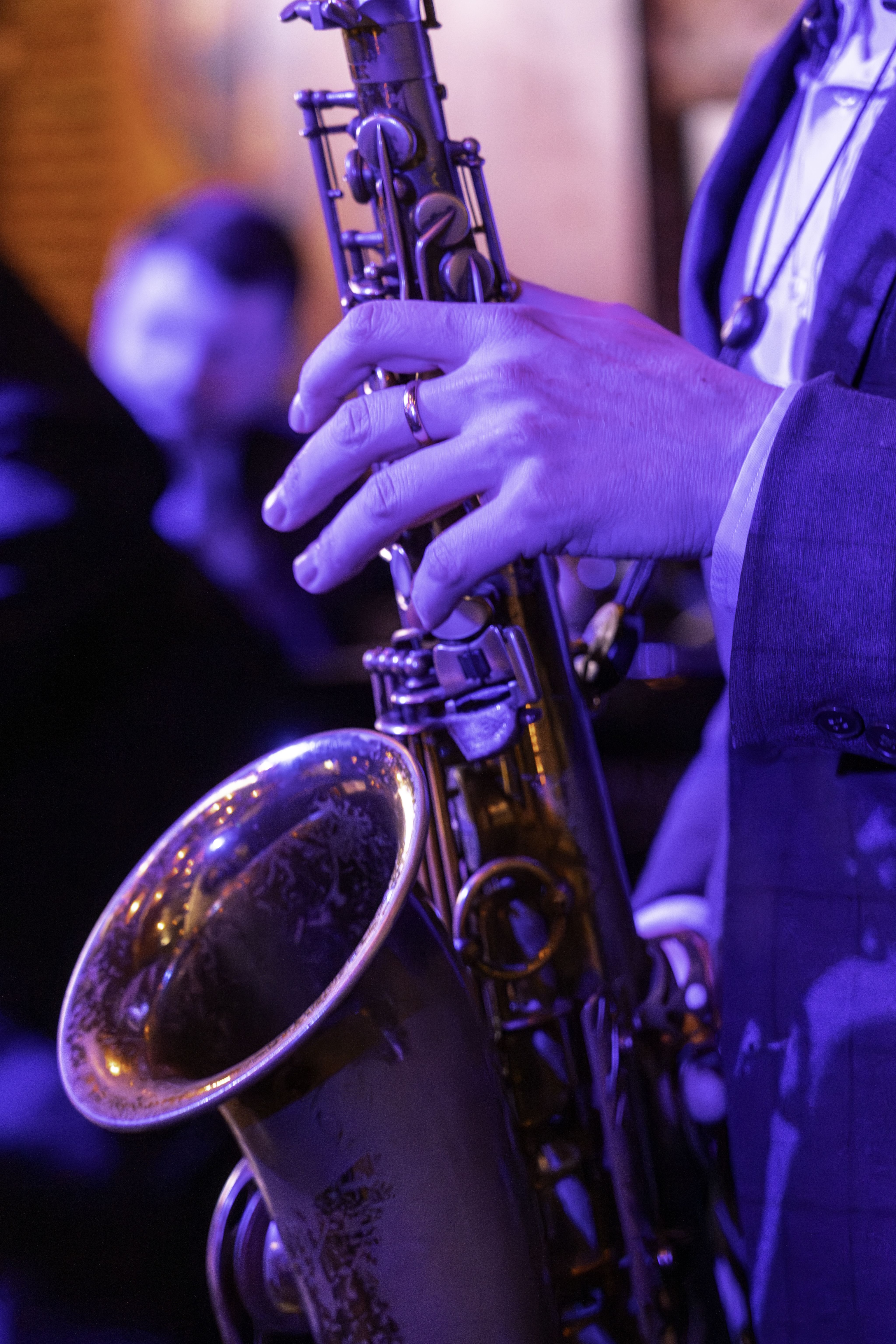 Close up shot of saxophone being played at Nocturne in purple and blue light.