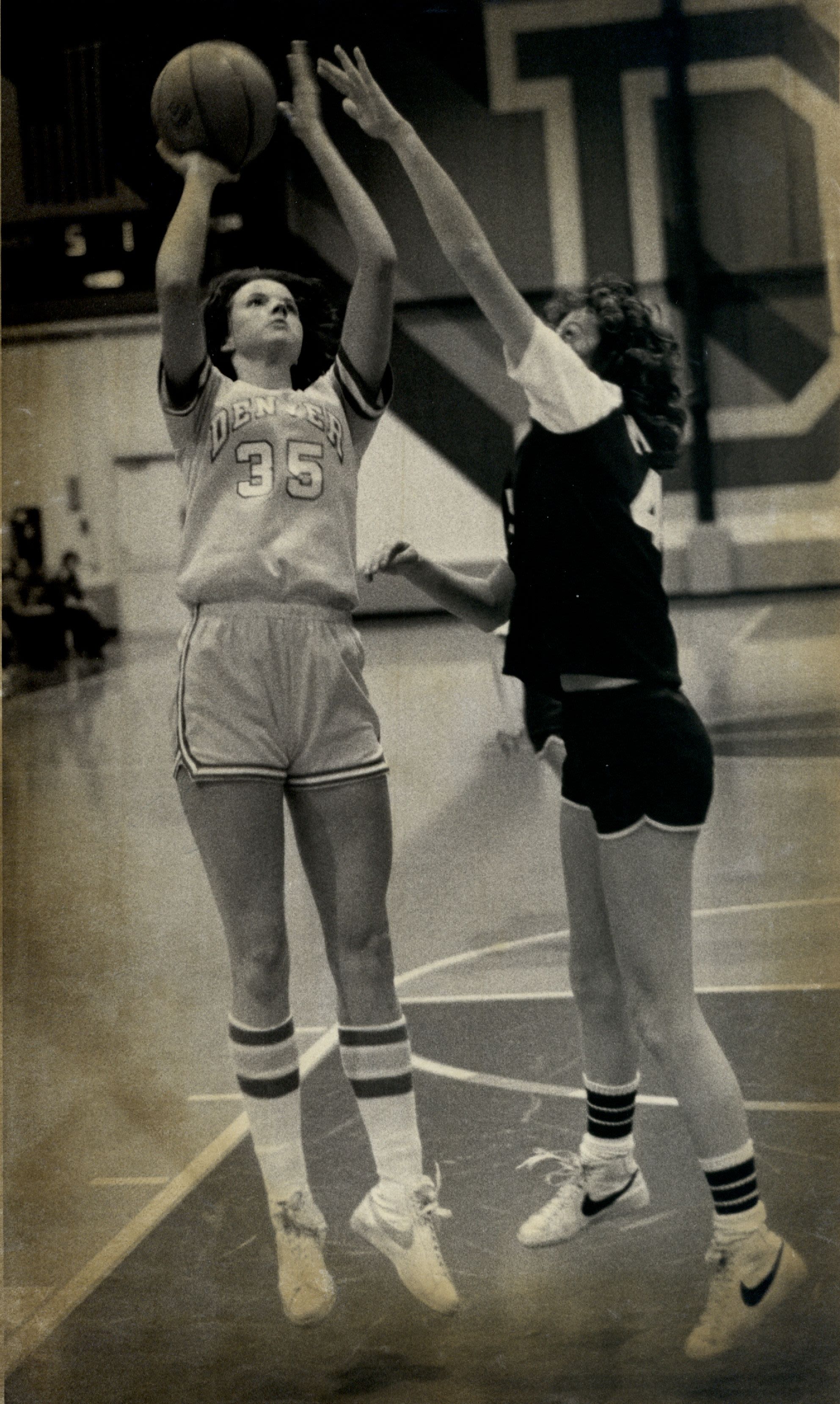 University of Denver (DU) Pioneers women's basketball player (35) prepares to take a right-handed shot against an opposing defender in a game at the DU Field House Arena in Denver, Colorado.