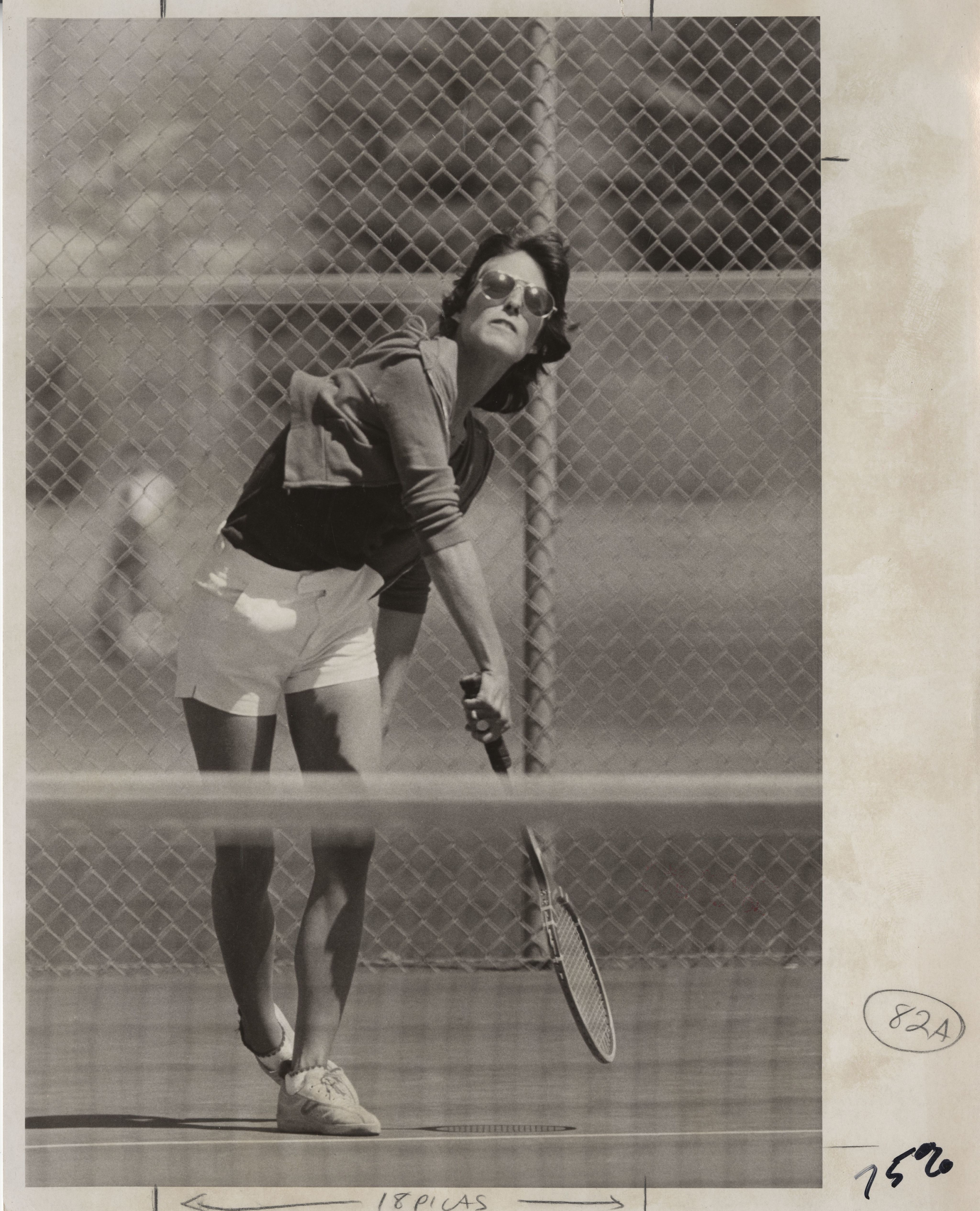University of Denver (DU) Pioneers women's tennis player serves the ball.