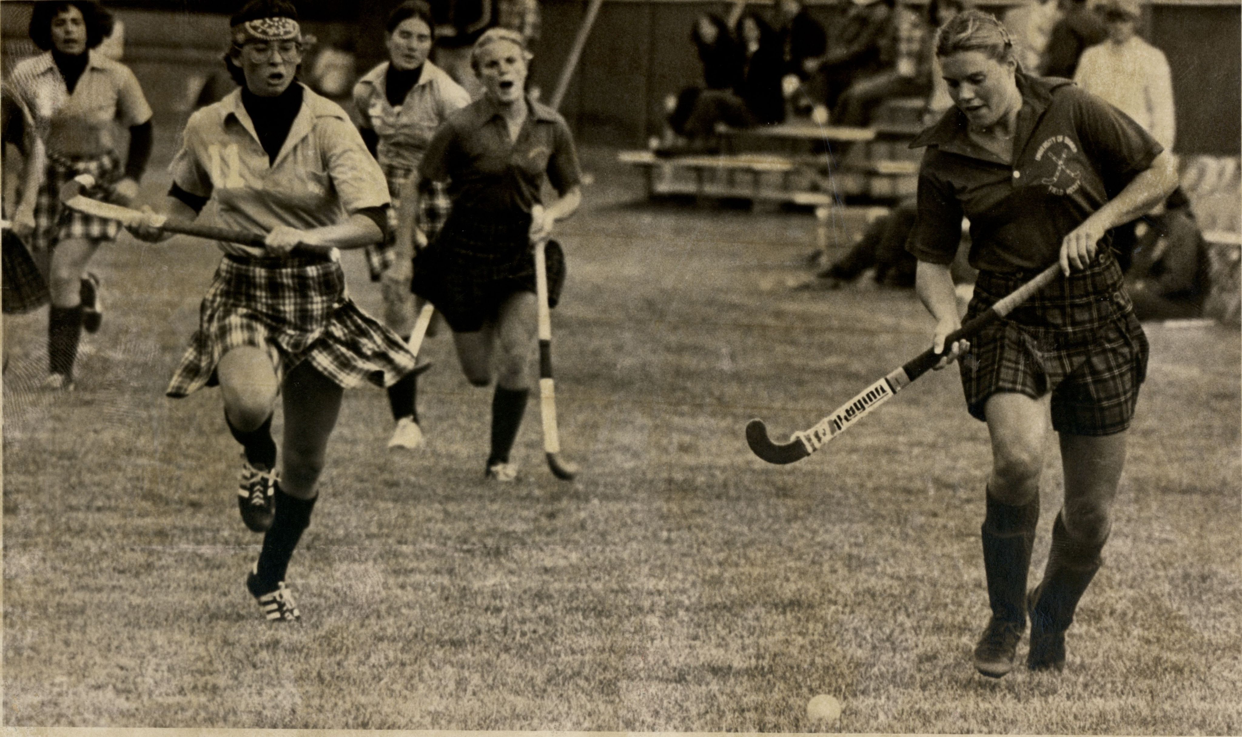 University of Denver (DU) Pioneers women's field hockey player gains possession of the ball as an opposing player sprints toward her during a match.