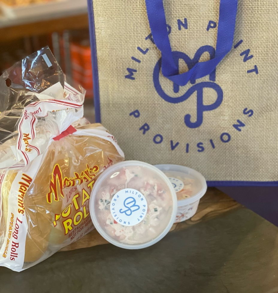 To-go meal prepared by Milton Point Provisions. Two containers of lobster meat, a pack of buns and a Milton Point Provisions tote bag are visible.