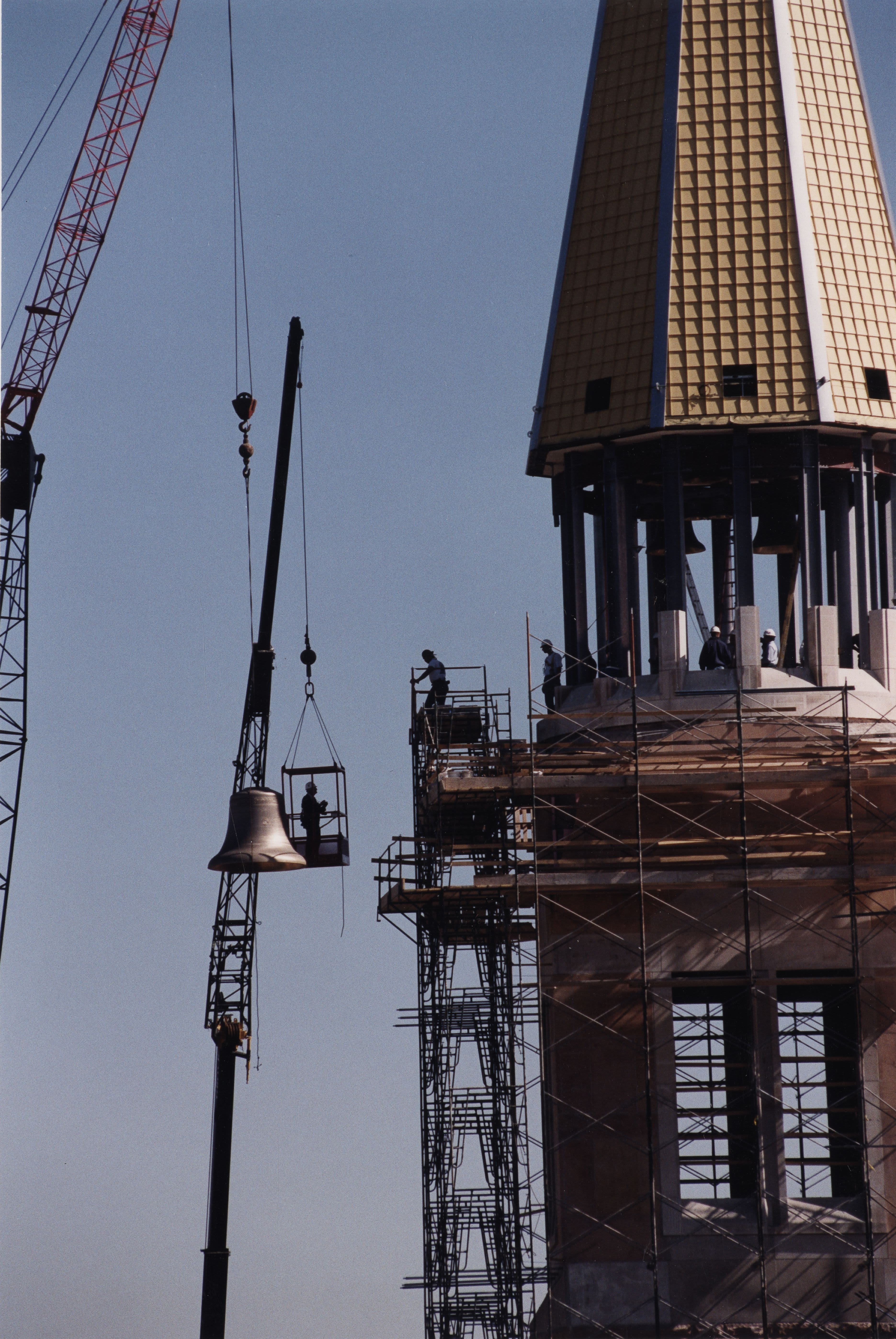 Workers using a crane to install bells in the DU Carillon