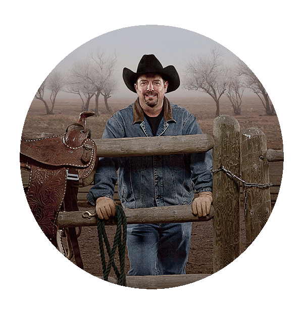 C.J.Box stands at a fence with horseback riding saddles. 