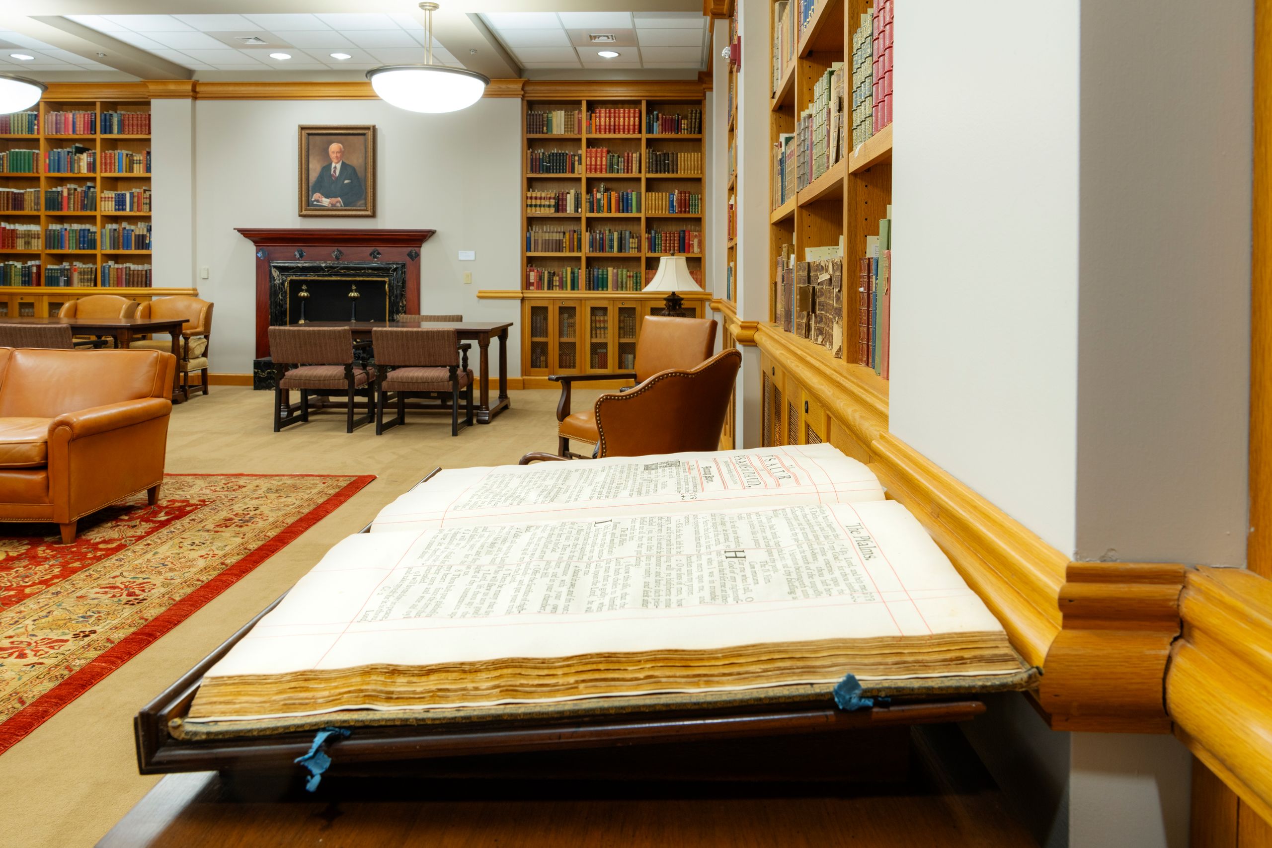 An old book open on a table with book cases in the background