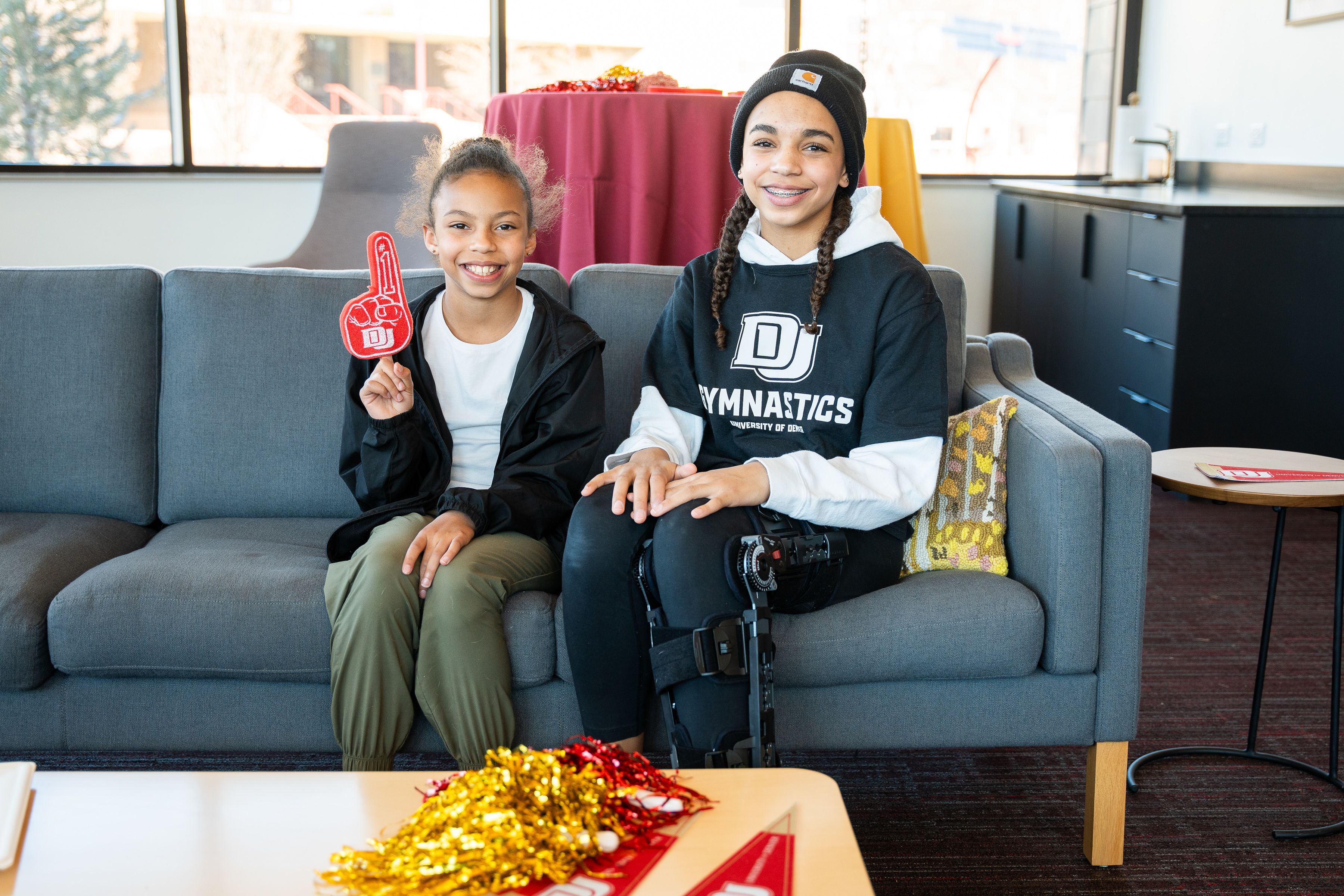 Two young DU Gymnastics fans sitting 