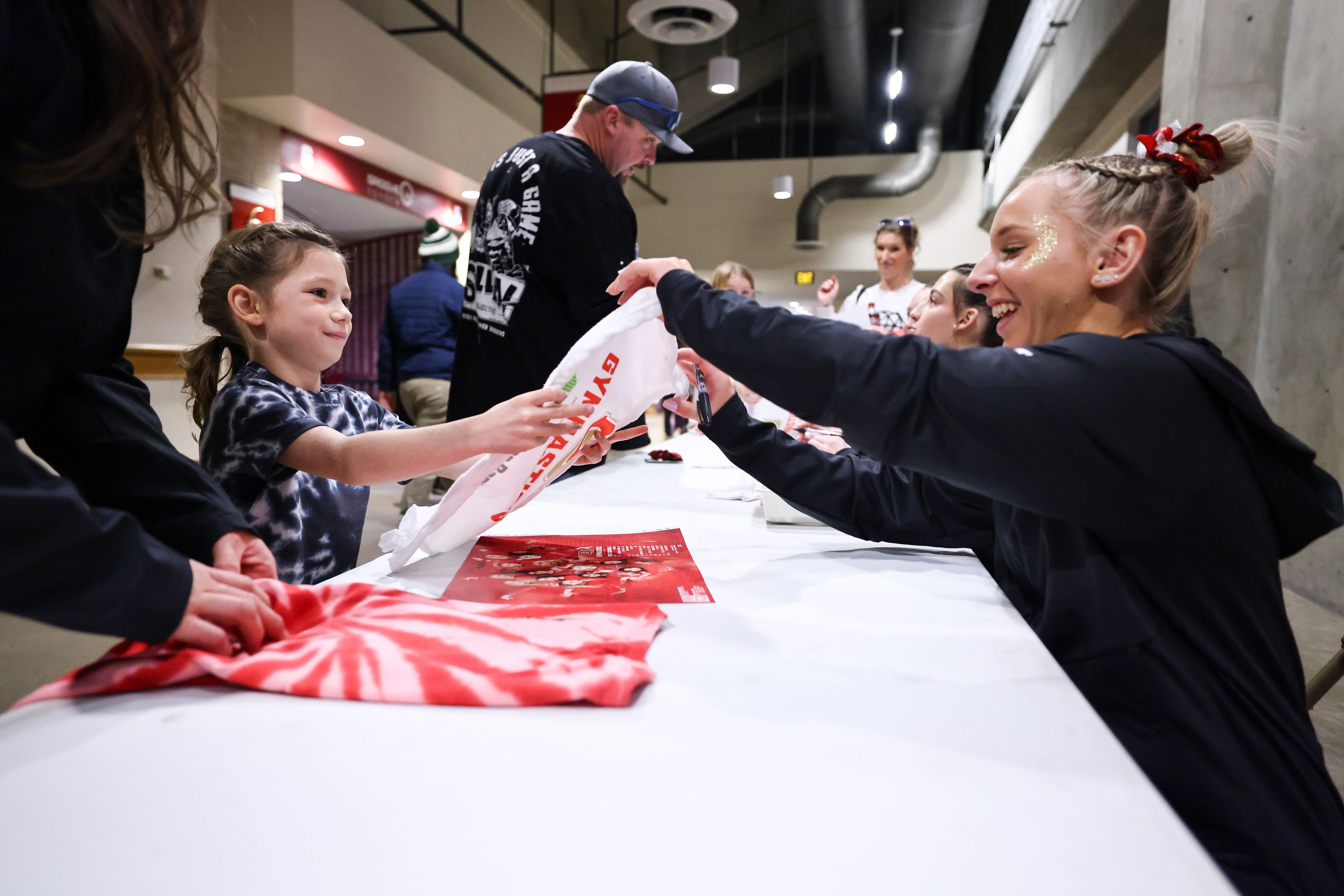 Maddison Reidenbach signing an autograph for a young fan