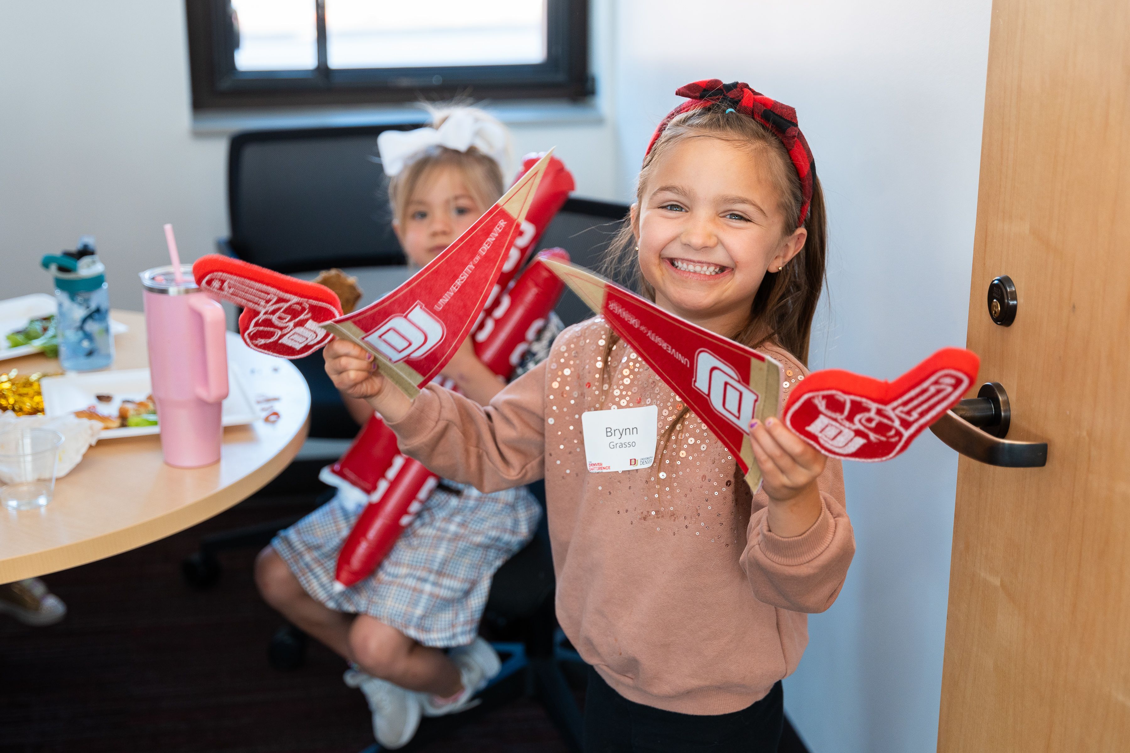 Two very young fans with foam fingers and DU swag