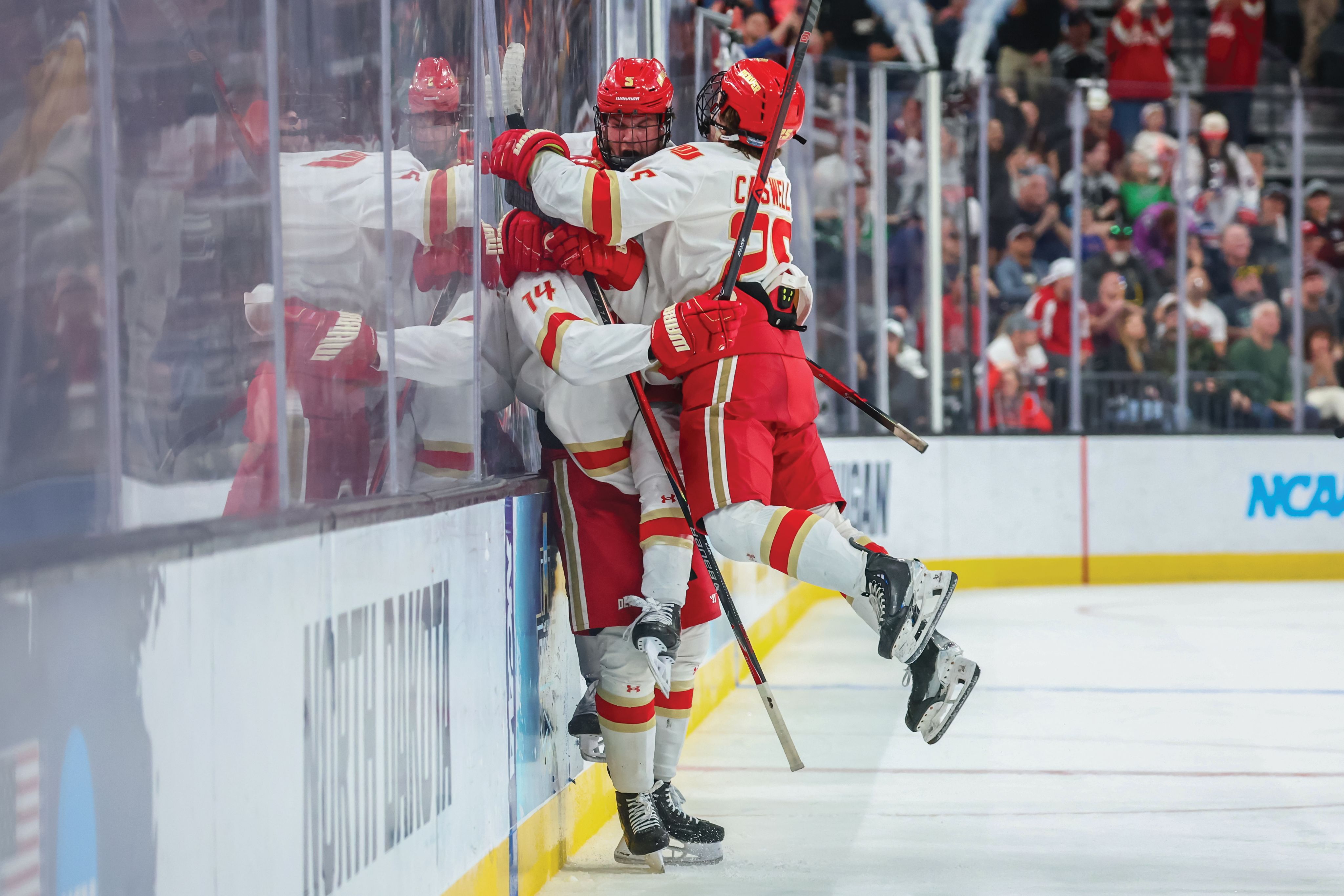 three hockey players celebrating on ice