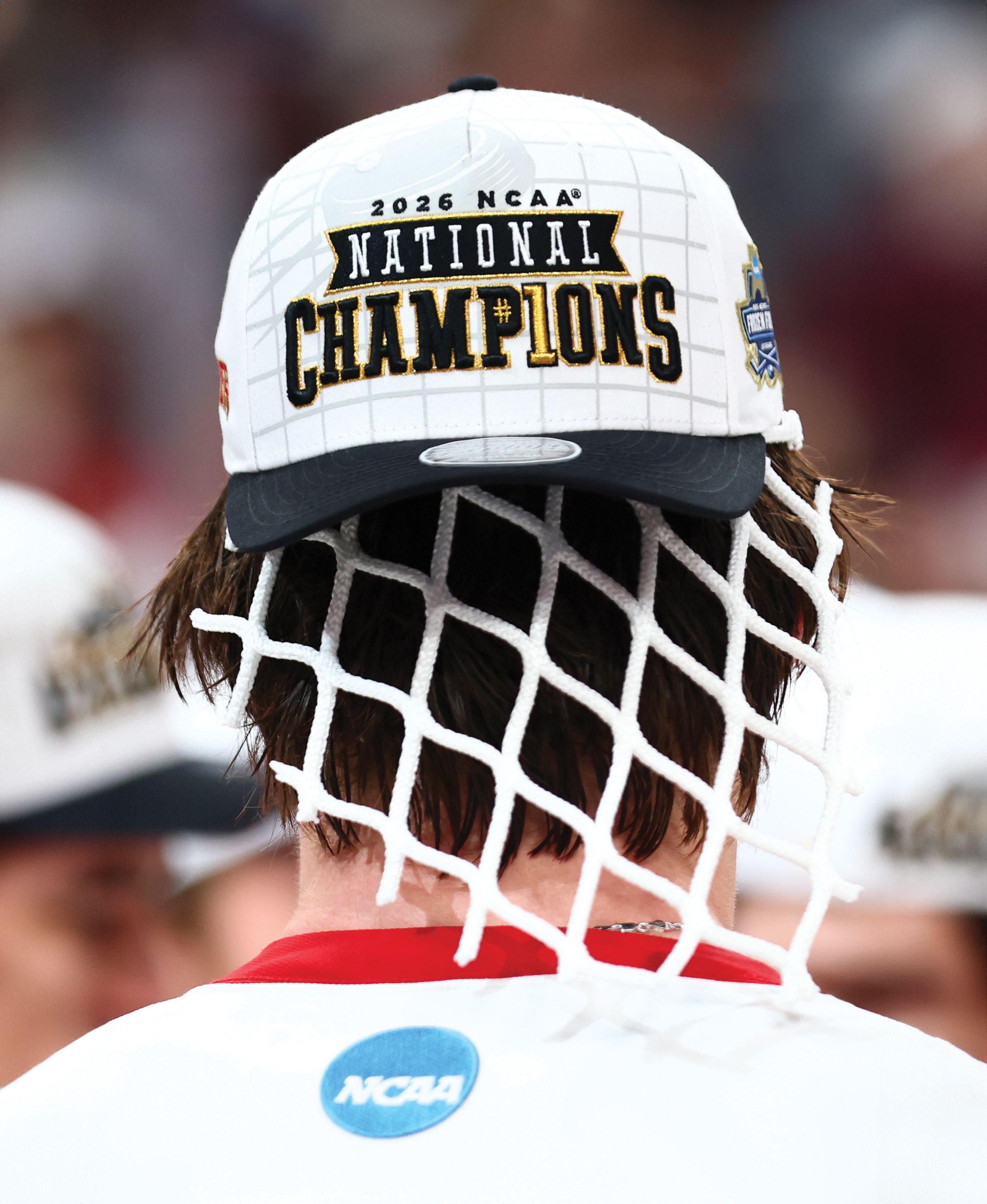 a hockey player wearing a hat with a piece of a hockey net on his head
