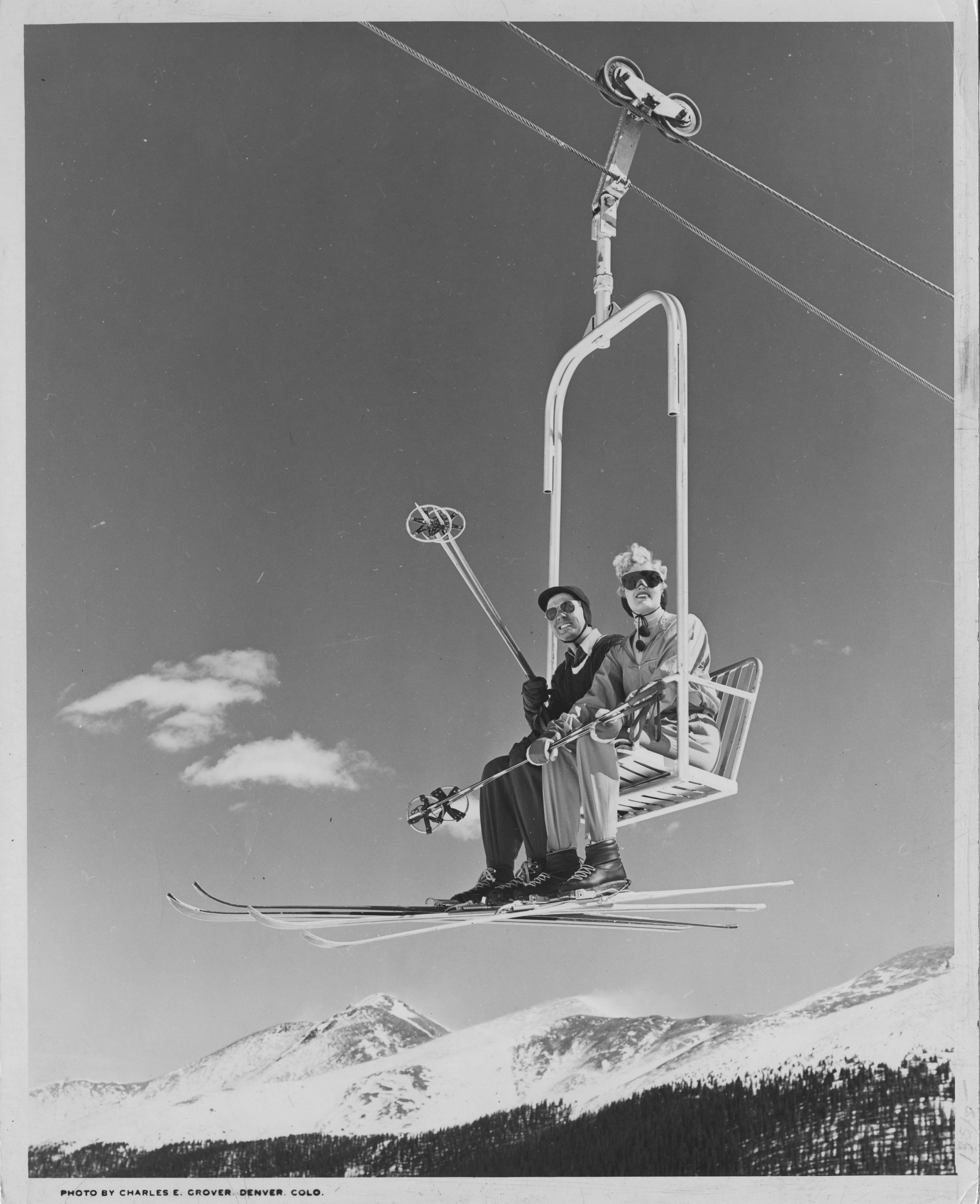 2 DU students are wearing ski headbands, sunglasses and holding poles as they look past the camera.