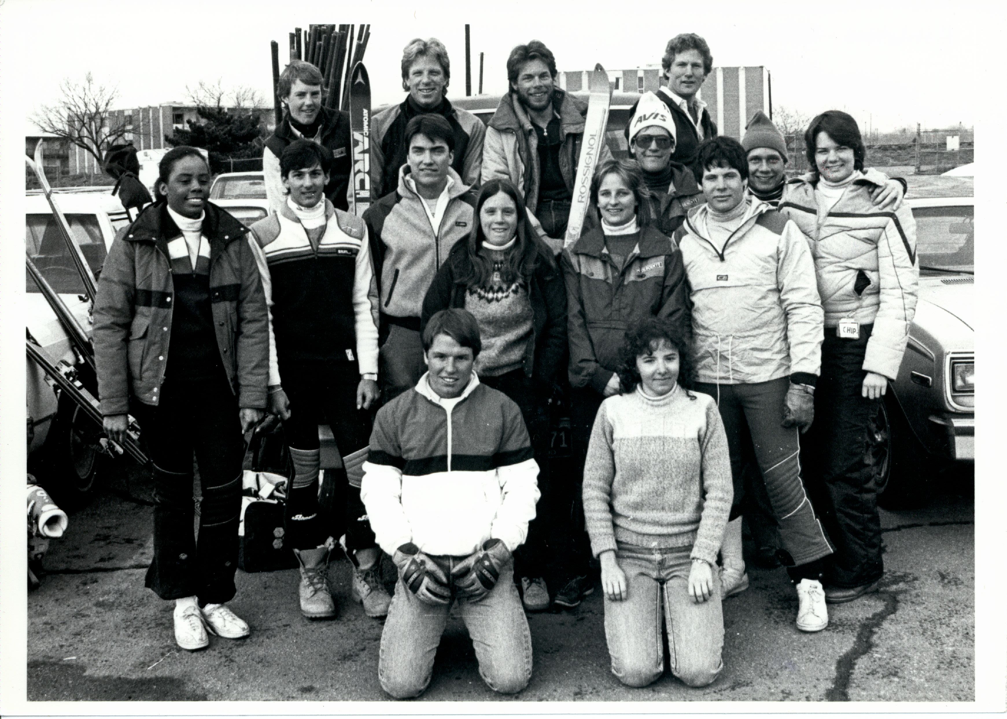 DU ski team poses for photo in the parking lot in their winter coats and with skies