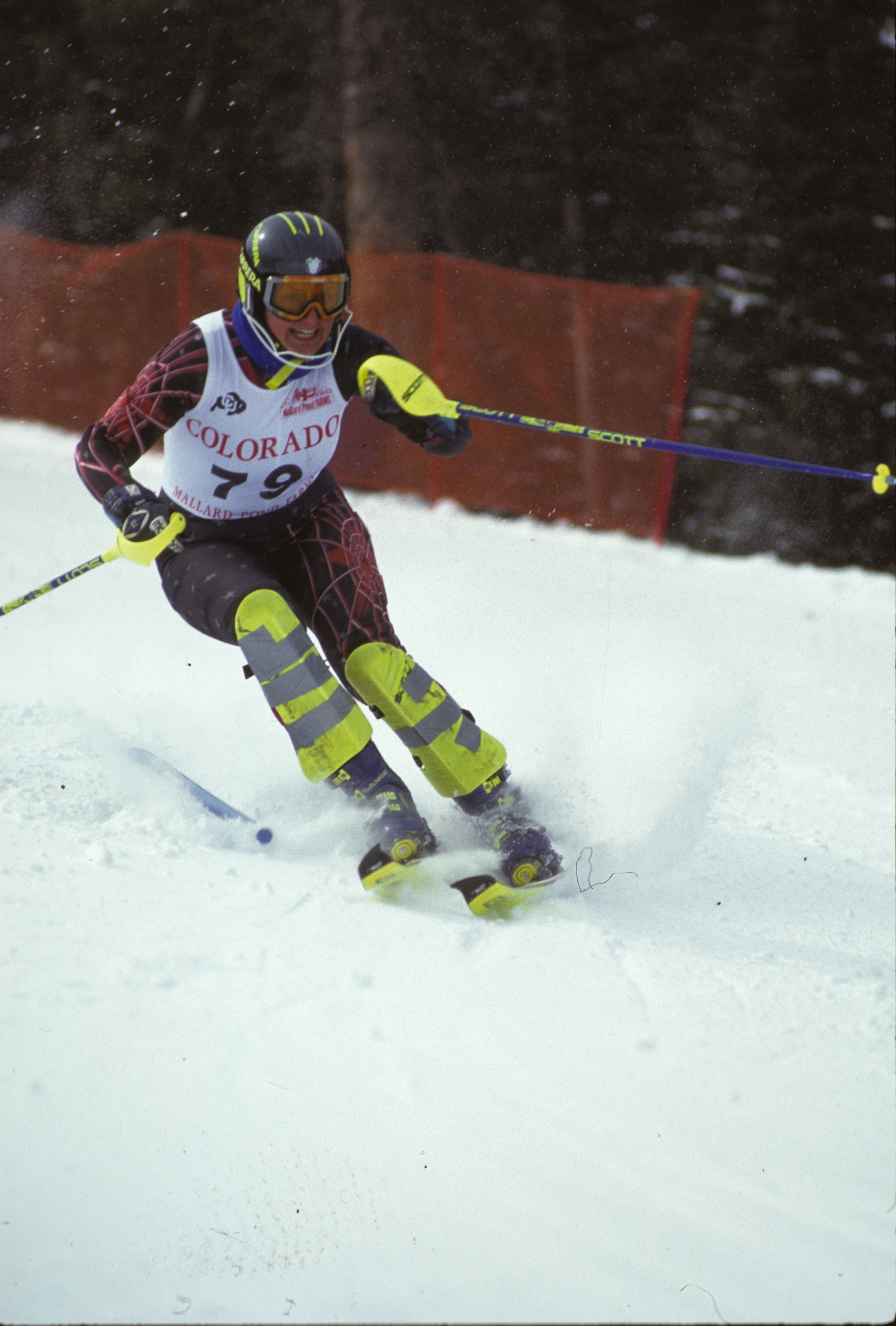 Pergher skis on her ski edges with her poles positioned near her chest as she turns, wearing bib number 79