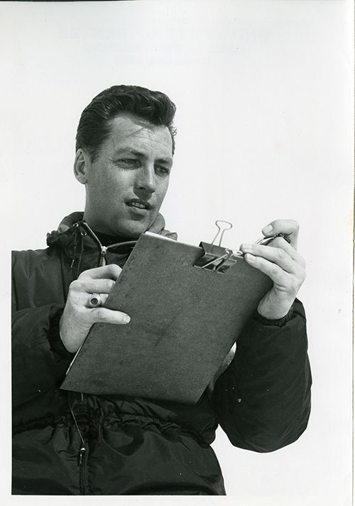 Peder Pytte looks down at his stop watch and a clip board 