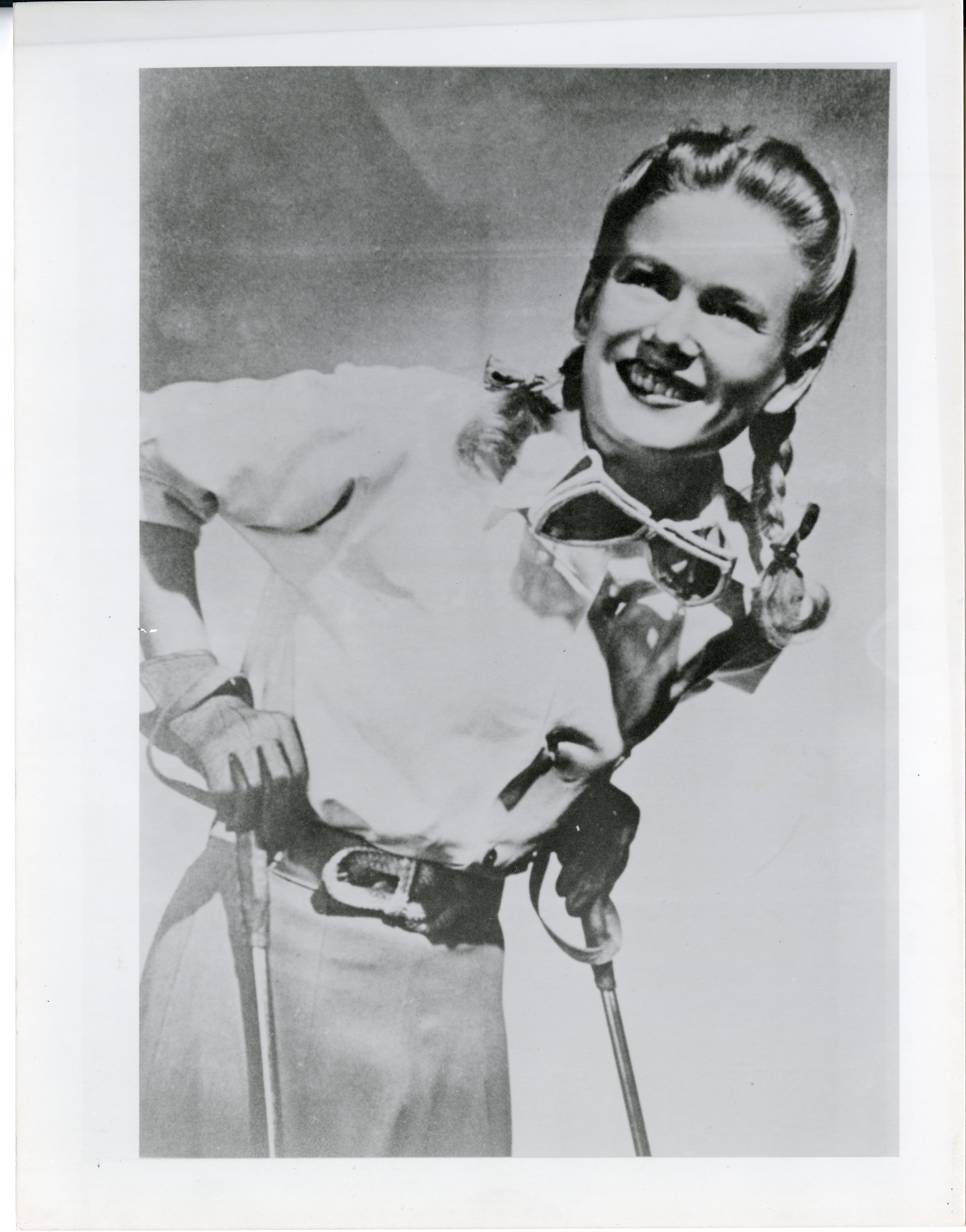 Barbara Kidder poses for a black and white portrait photo with goggles hanging around her neck
