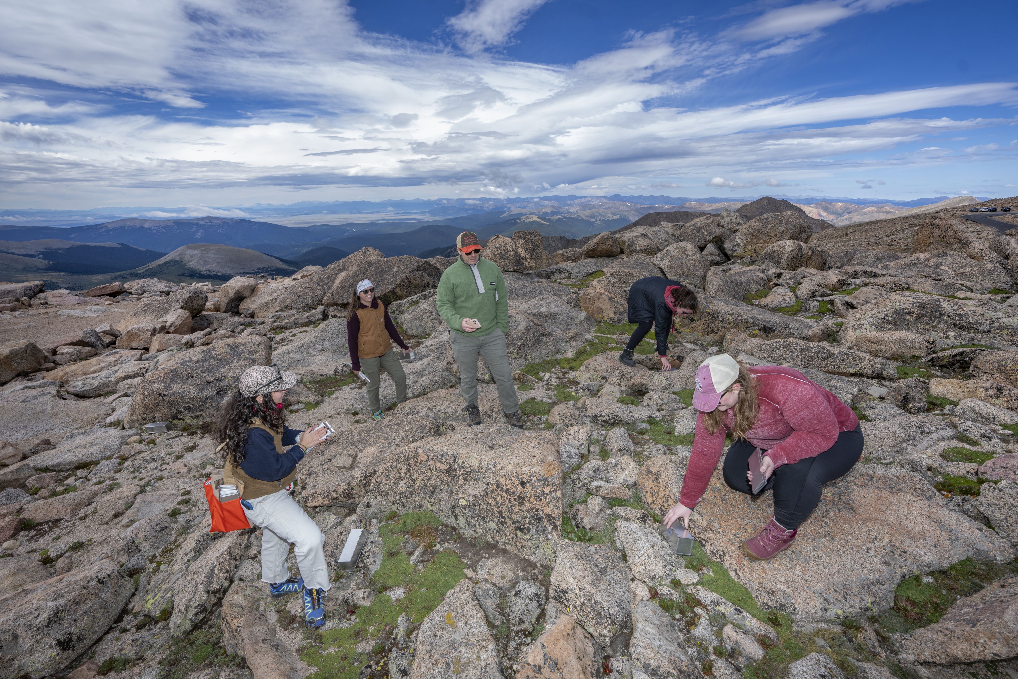 A group of researchers with metal traps on top of Mount Blue Sky.