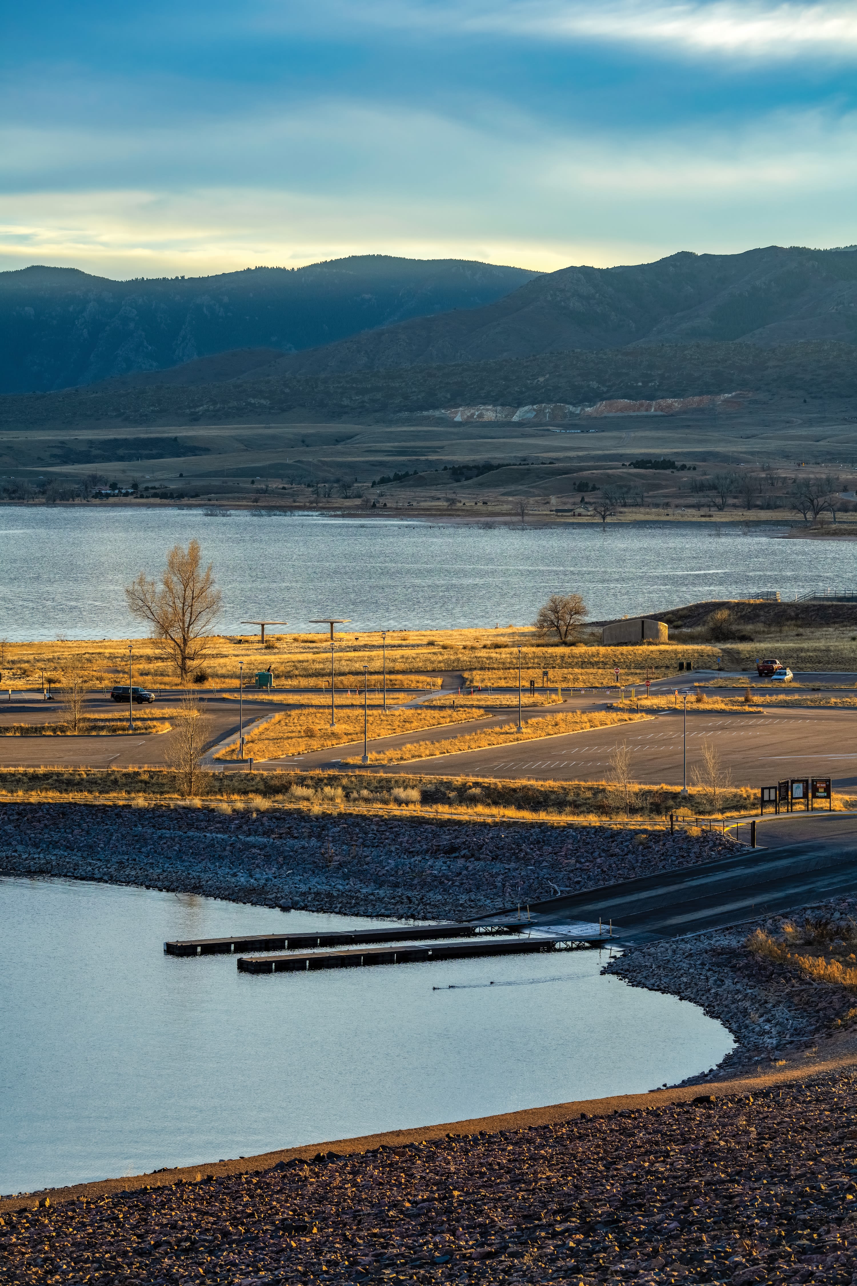 a lake in the foreground with foothills in the background