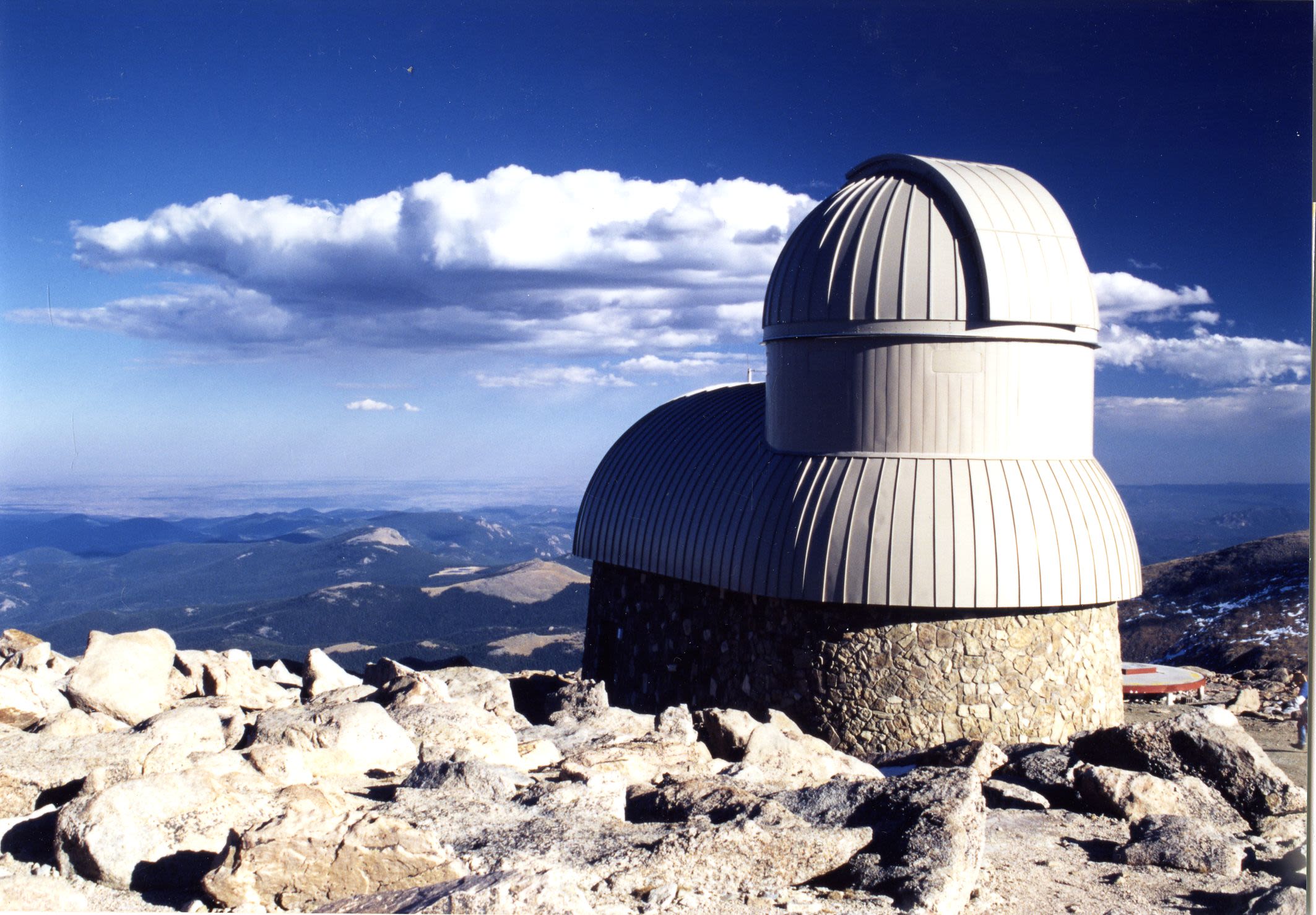 A photo of the Meyer-Womble Observatory with blue sky and clouds in the background