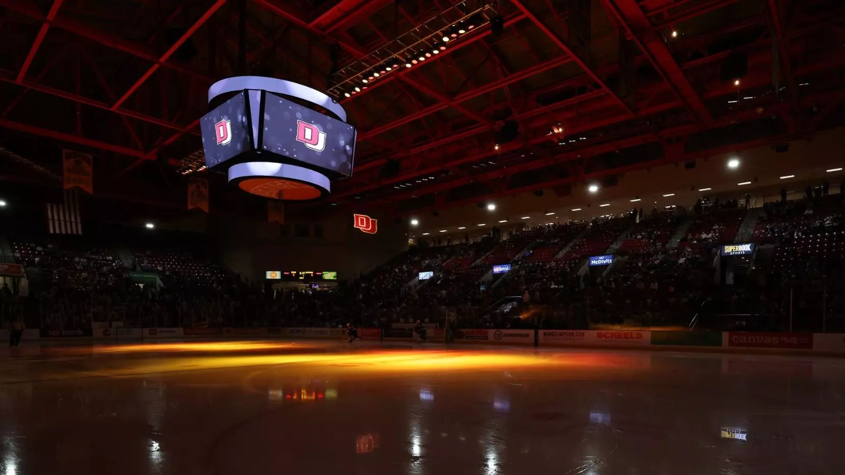 A photo of Magness Arena, full of students with the lights low before a hockey game