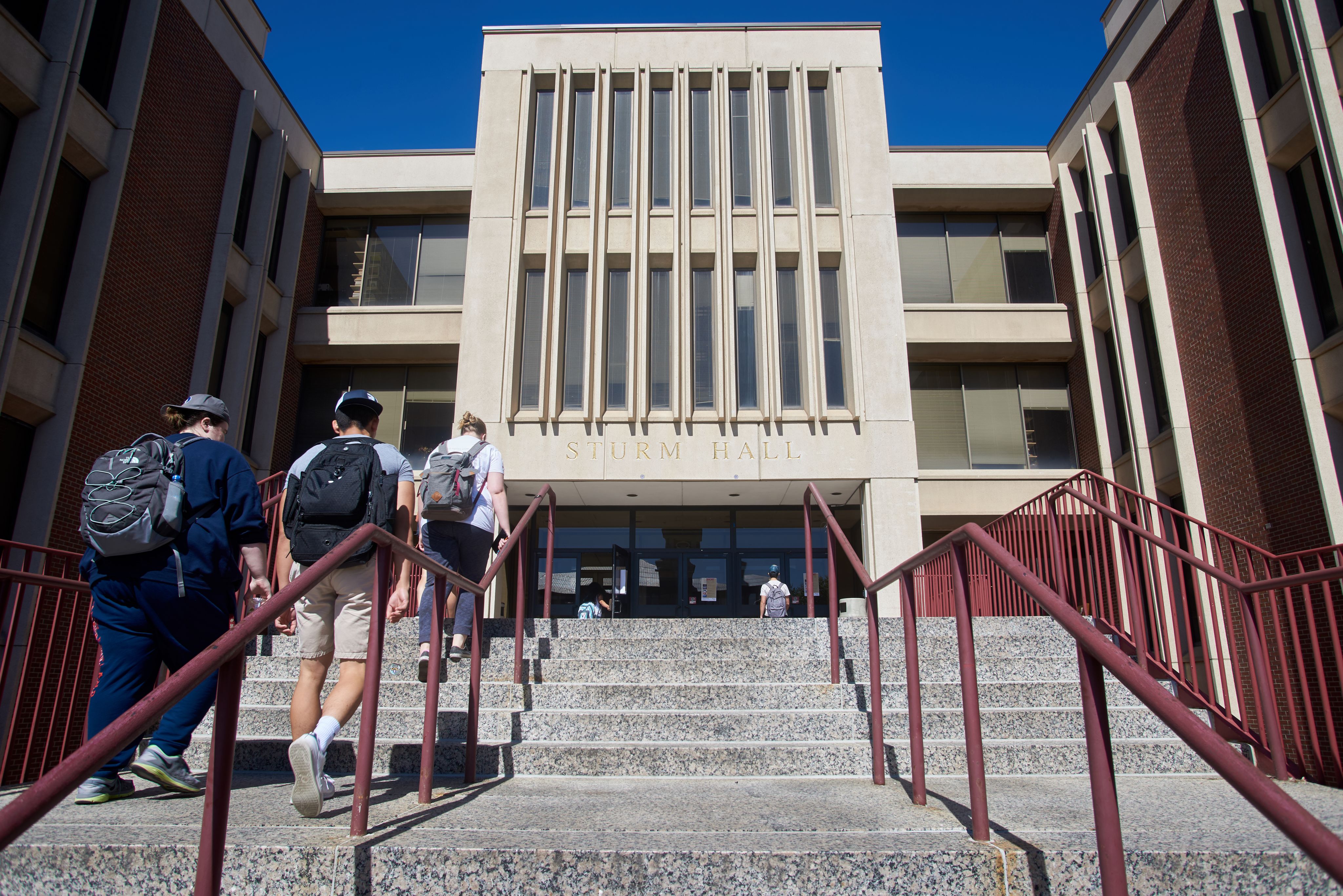 Students walking up the stairs to the front entrance of Sturm Hall