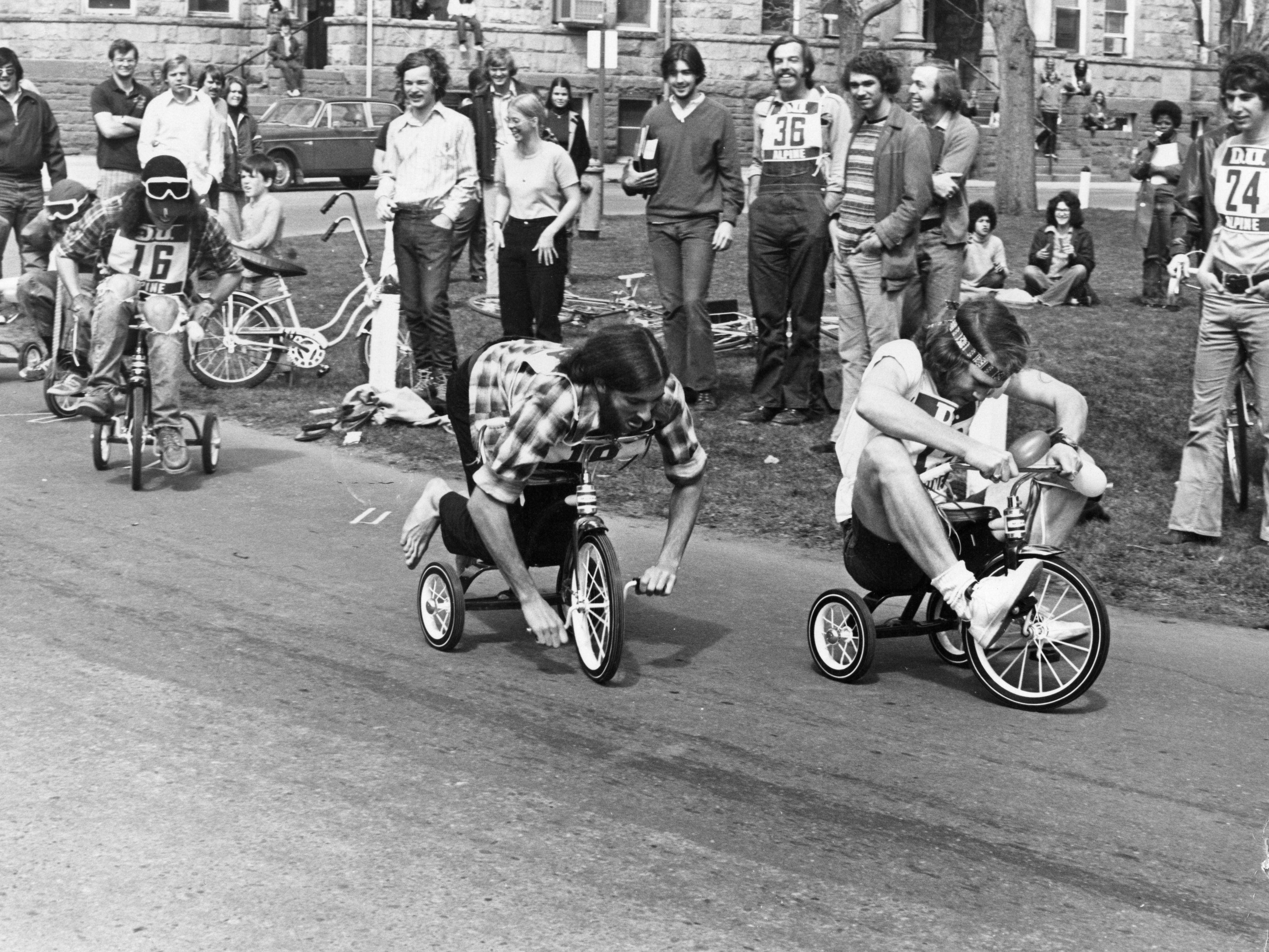 Students participate in a Spring Carnival tricycle race in front of University Hall.