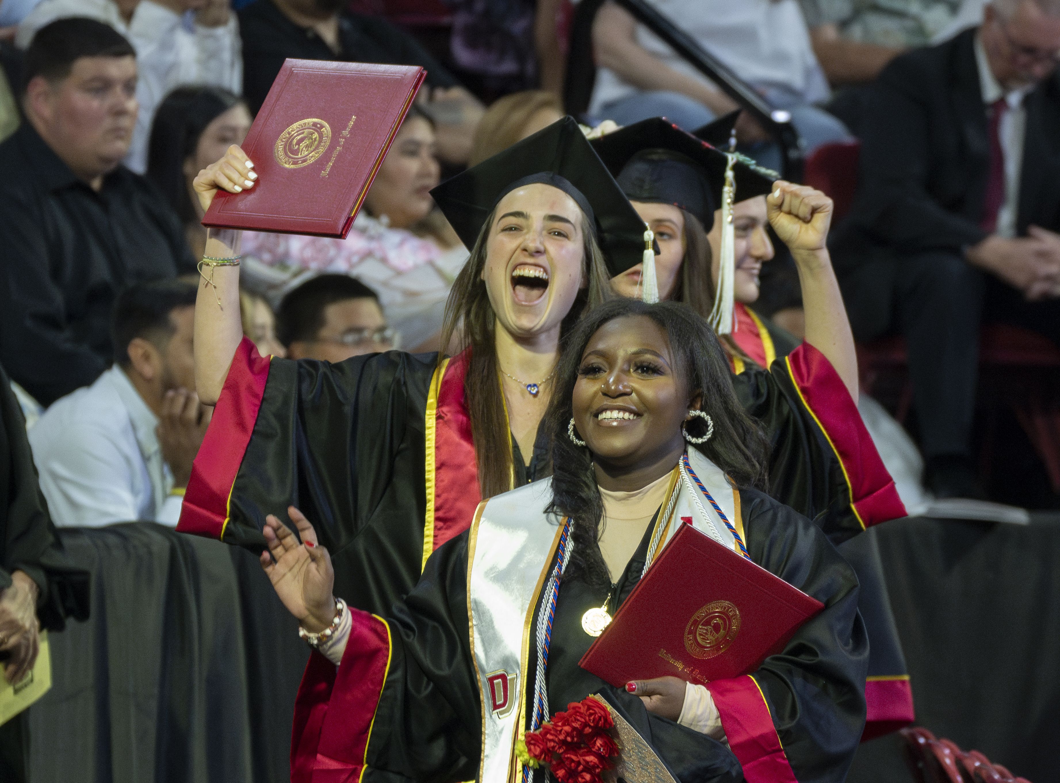 Two students cheering at graduation