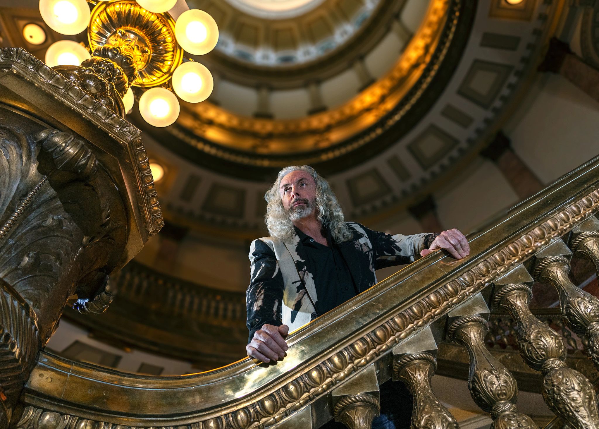 Portrait photo of alumnus Tom Rodgers, with the interior of the Colorado State Capitol's dome visible in the background