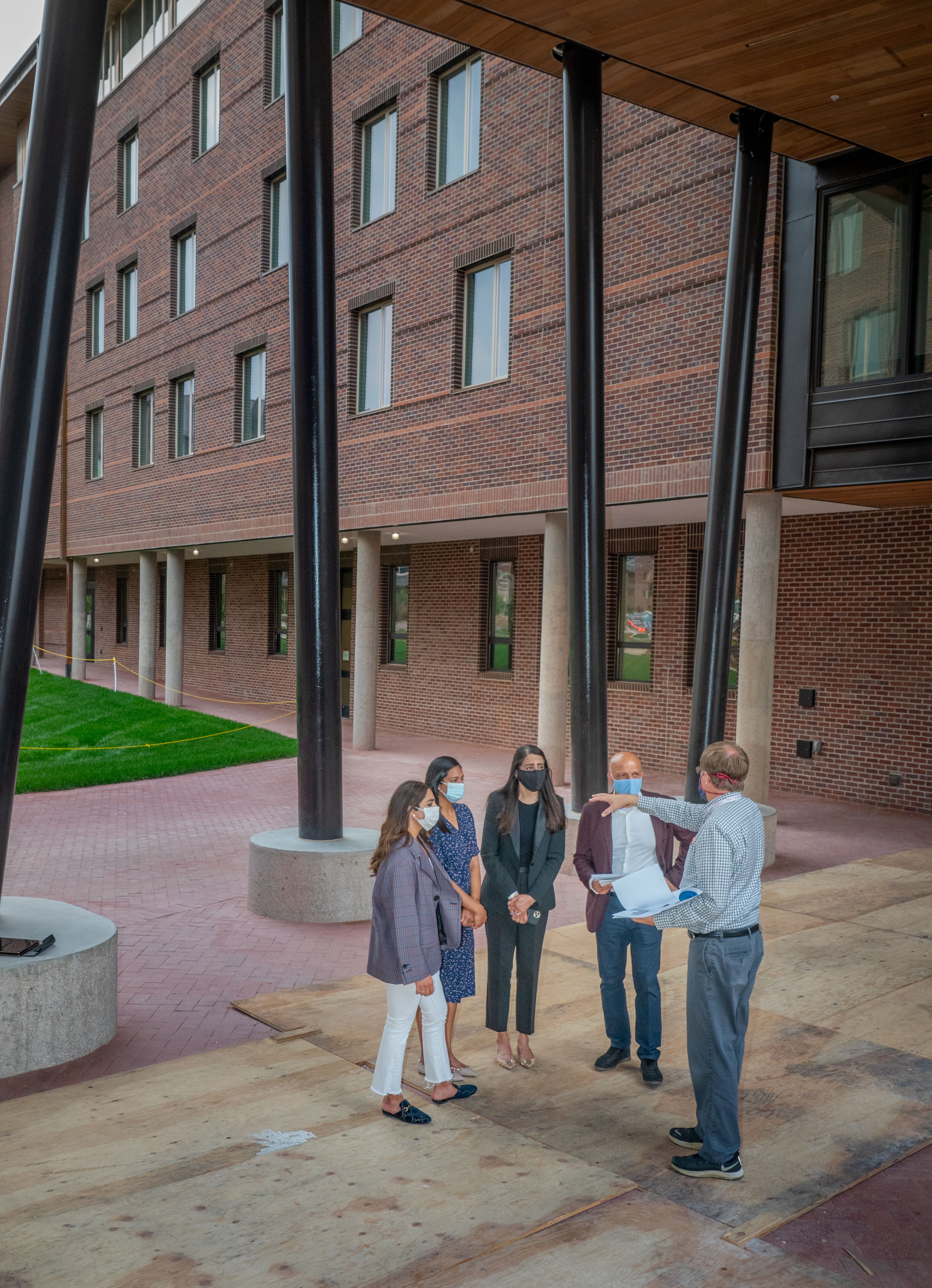 The Dimond family stands under the entryway of the Dimond Family Residential Village.