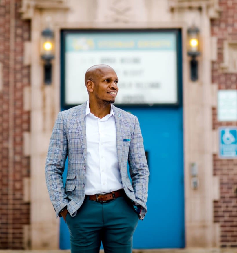 Photo of Michael Atkins in front of a brick building