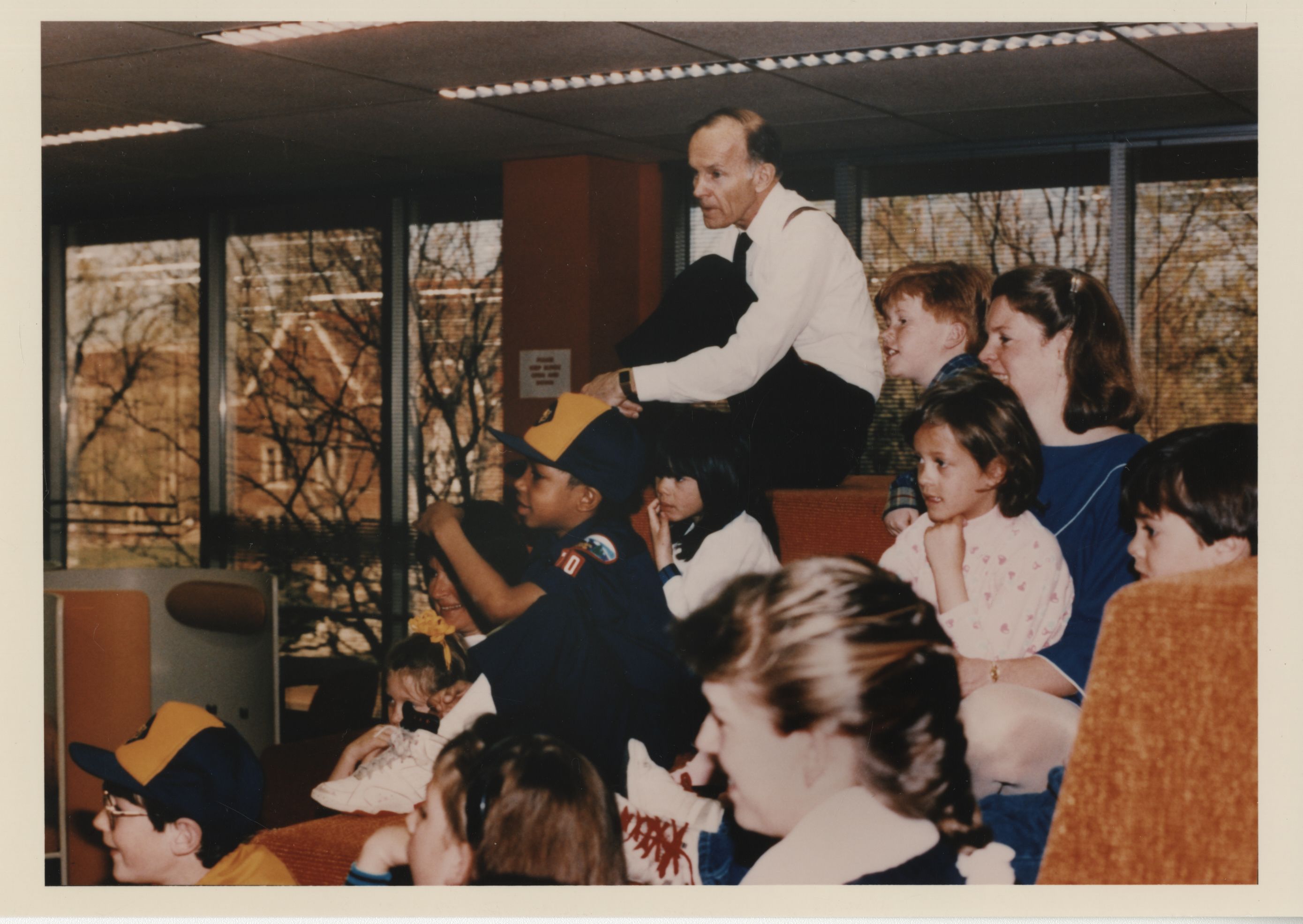 Dan Ritchie sitting in a classroom with young students.