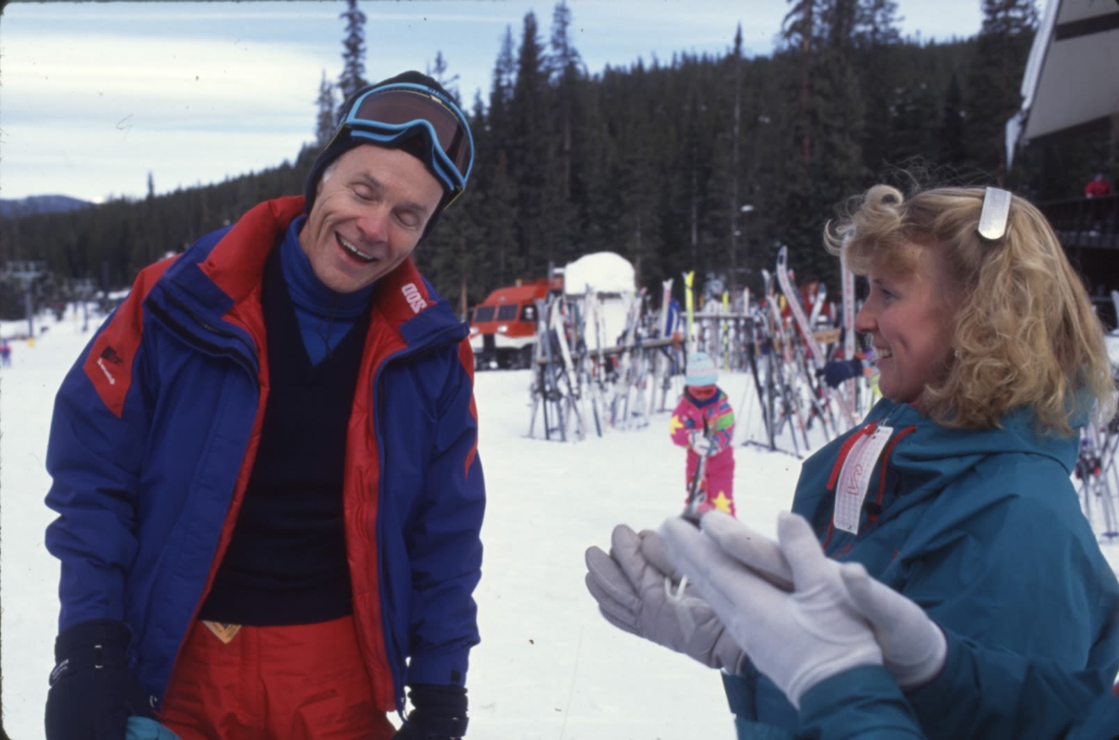 Dan Ritchie in ski gear talking to a student at a mountain.
