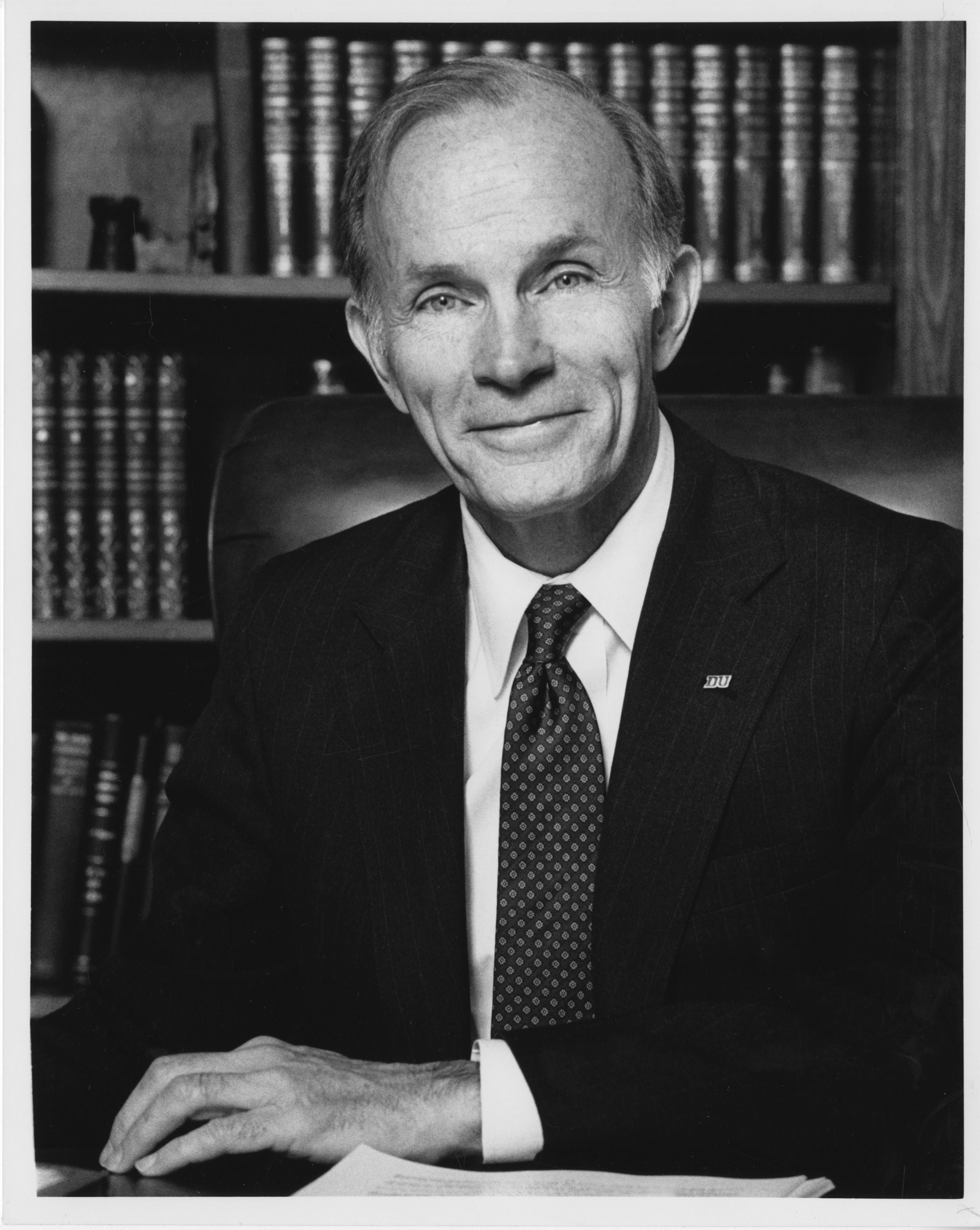 A portrait photo of dan ritchie sitting at a desk