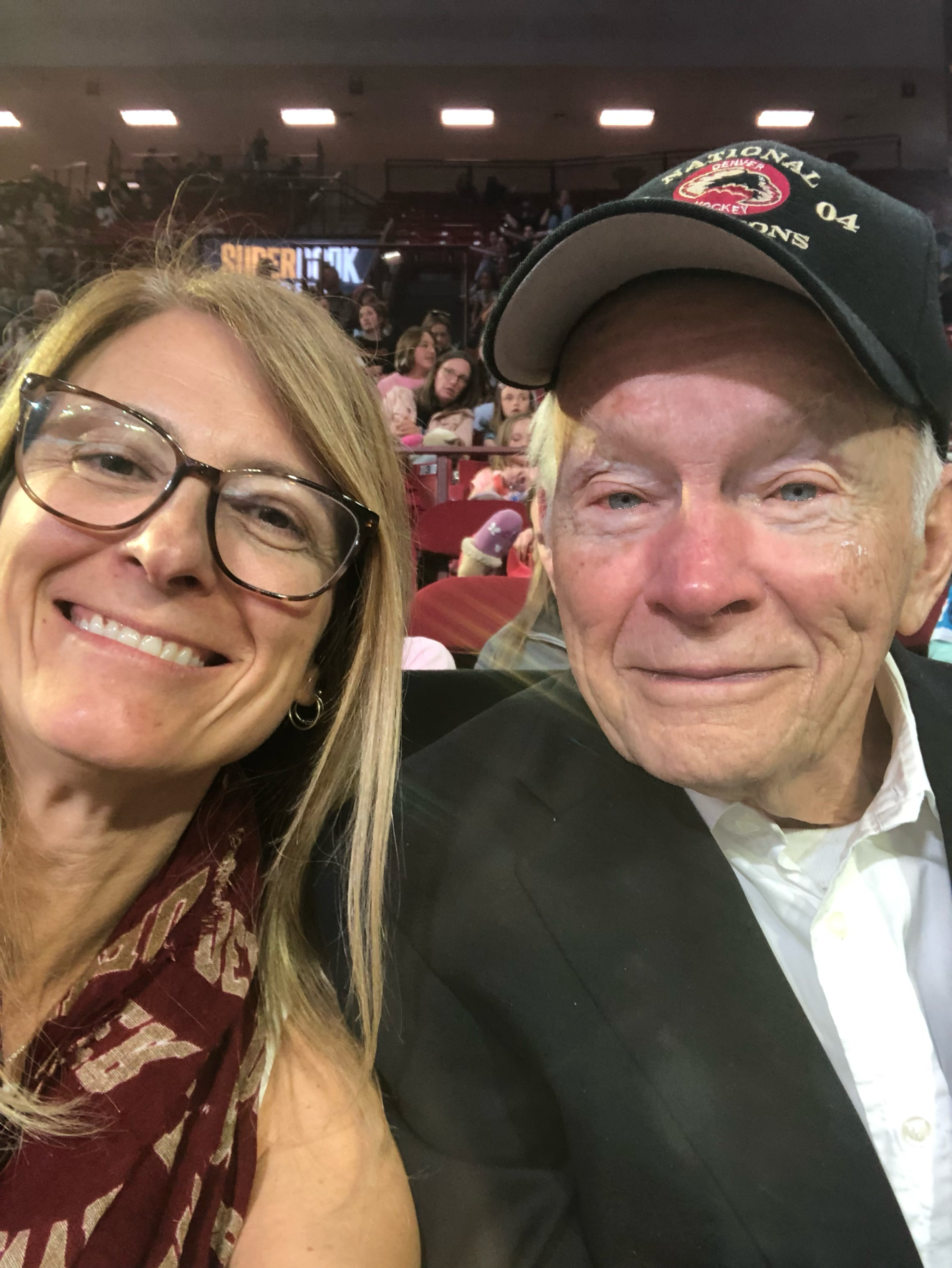A woman in glasses and Dan Ritchie in a baseball cap, posing for a selfie