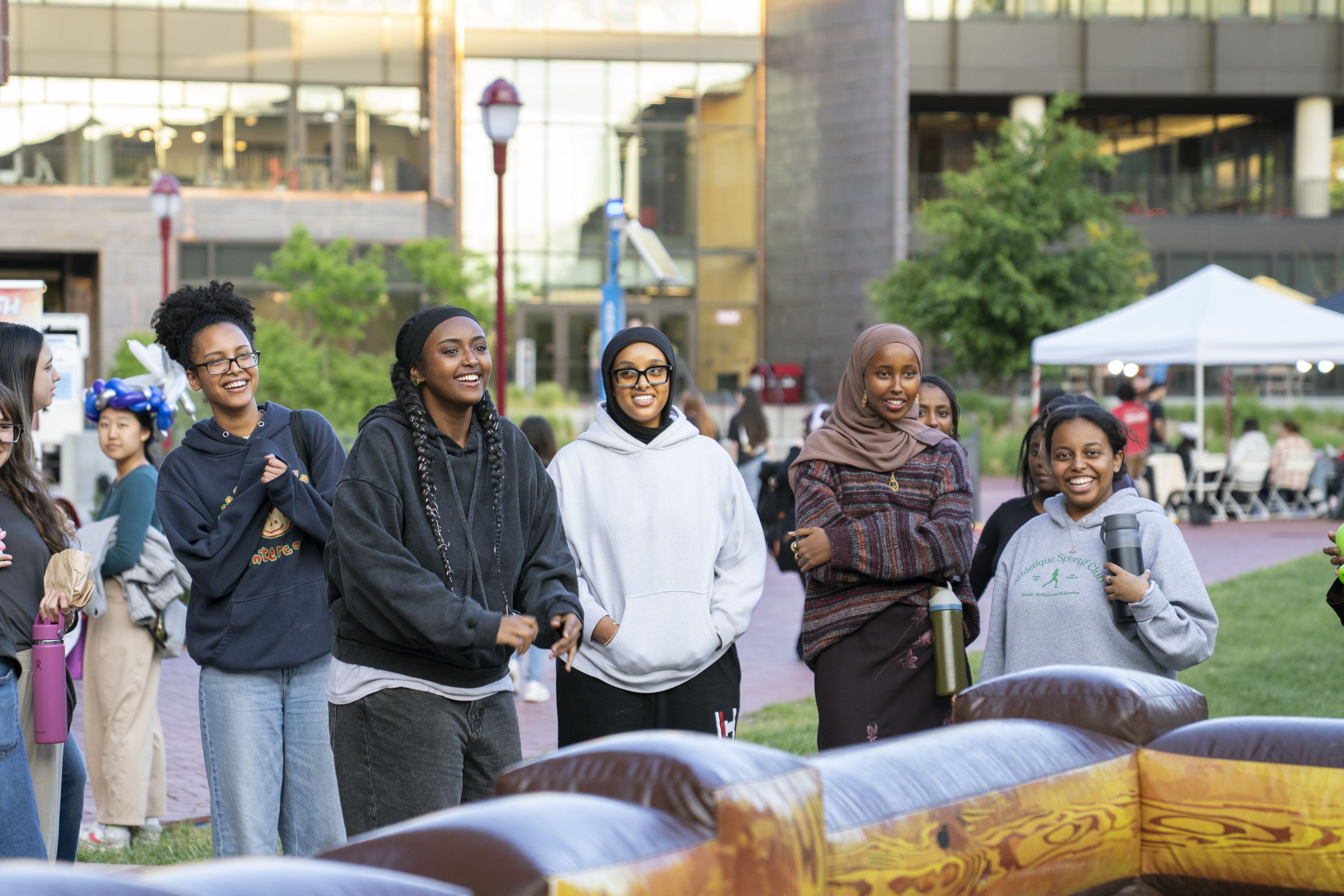 Students smile at a Student Affairs outdoor event on the Campus Green