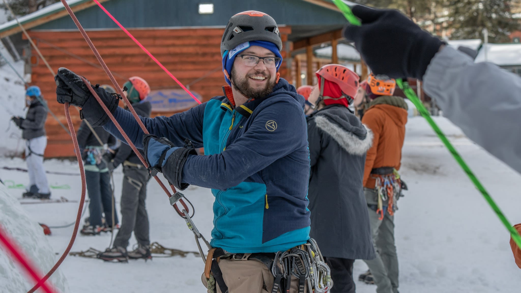 Student smiles while holding outdoor winter gear